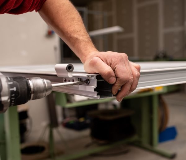 A male with a red shirt making a window with industrial tools